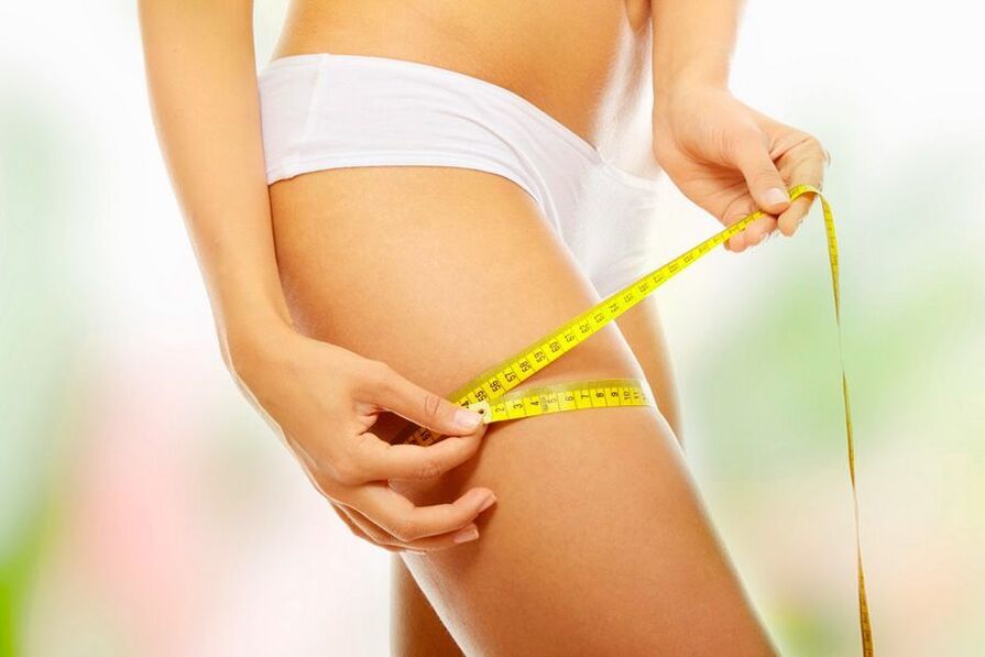 The girl measures her volume of the thigh