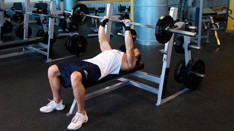 To dry the shoulders and chest, a barbell bench press is performed on a horizontal bench. 